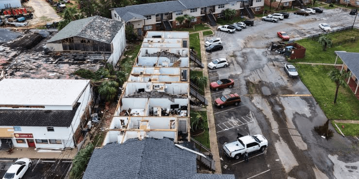 Aerial view of storm-damaged buildings and parked cars in a residential area