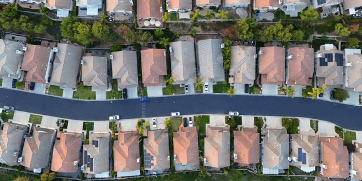 Aerial view of suburban neighborhood with neatly arranged houses and tree-lined streets
