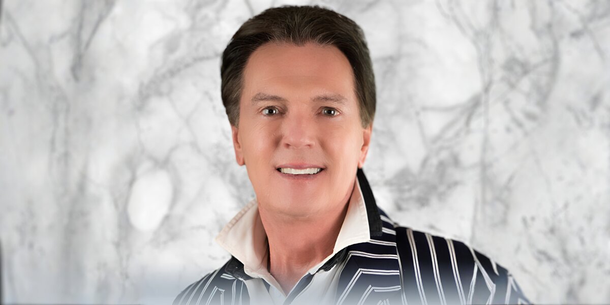 Greg Gunter, a luxury real estate broker, smiles in a striped jacket, embodying professionalism in San Miguel de Allende.