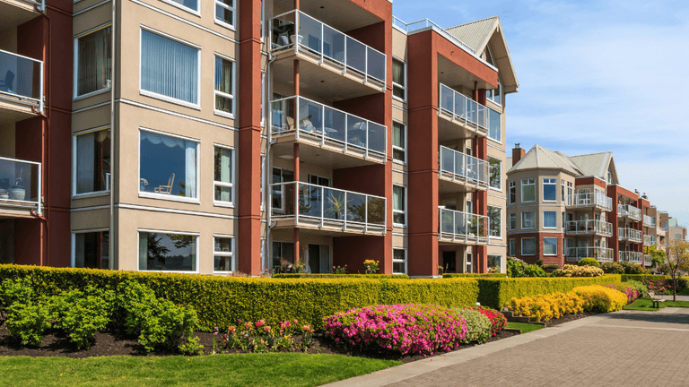 Modern apartment buildings with landscaped walkways and balconies in a multifamily residential community.