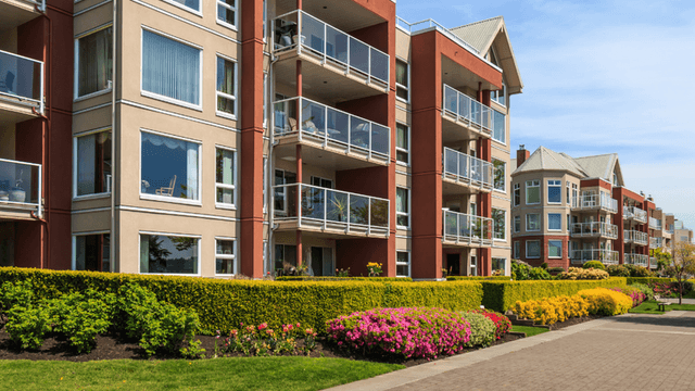 Modern apartment buildings with landscaped walkways and balconies in a multifamily residential community.