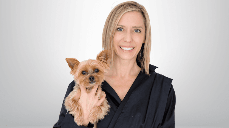 "Renée Ruth, real estate coach and founder of Platinum Agent Accelerator, smiling while holding a small dog."