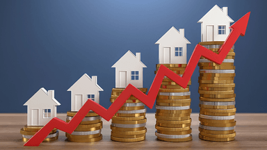 Growing real estate market represented by houses and stacked coins with an upward trend arrow