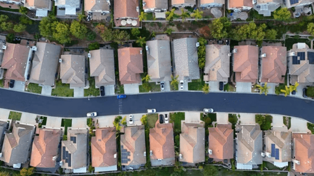 Aerial view of suburban neighborhood with neatly arranged houses and tree-lined streets