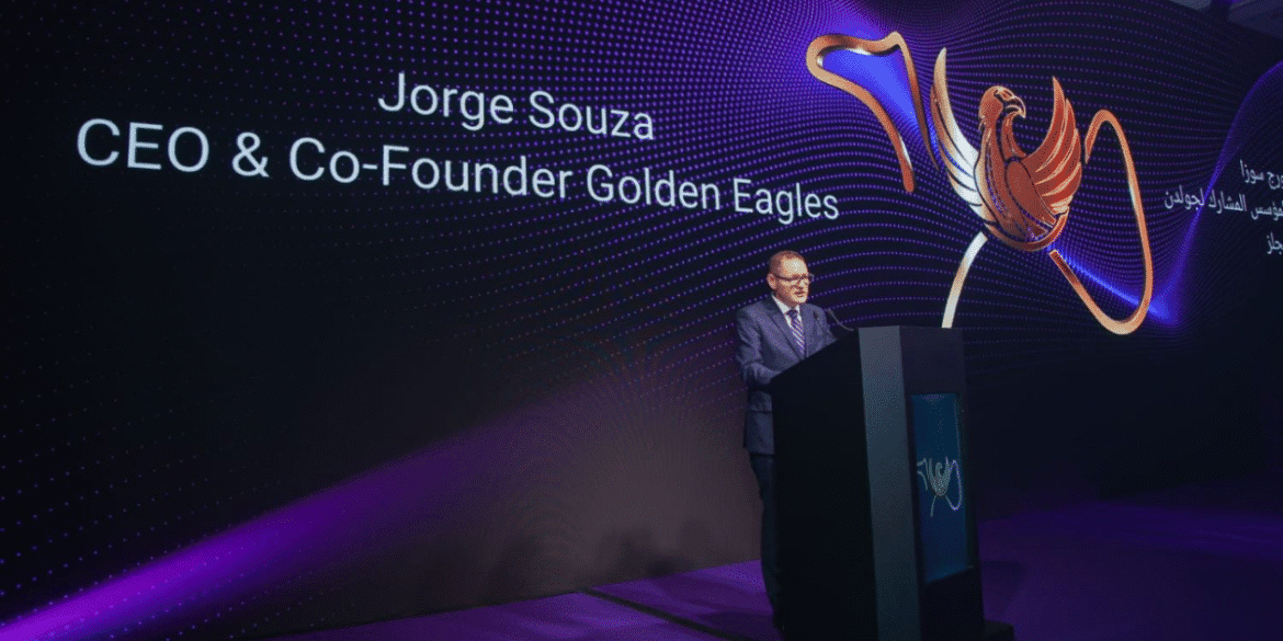 Jorge Souza speaks at event with Golden Eagles logo, highlighting global business expansion and strategic partnerships.