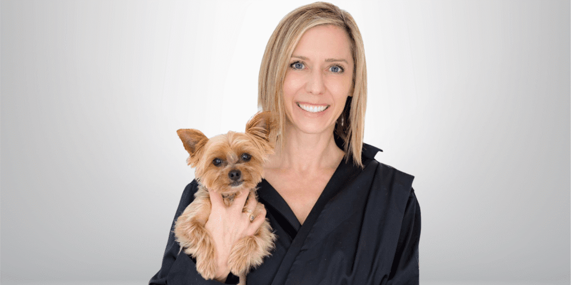 "Renée Ruth, real estate coach and founder of Platinum Agent Accelerator, smiling while holding a small dog."