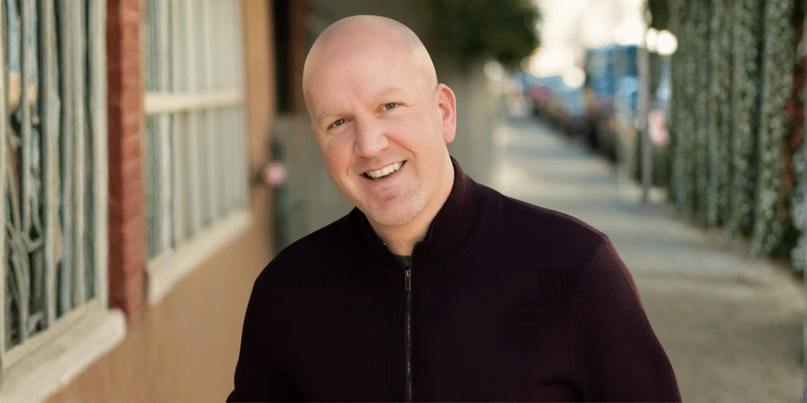 Ryan Weible, Bay Area Realtor, smiling in a professional setting with a city street in the background.