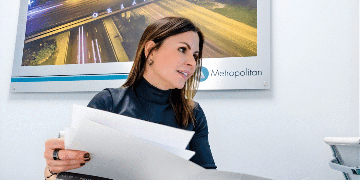 Alejandra Silva reviews real estate documents at Metropolitan Real Estate Solutions office in Florida.