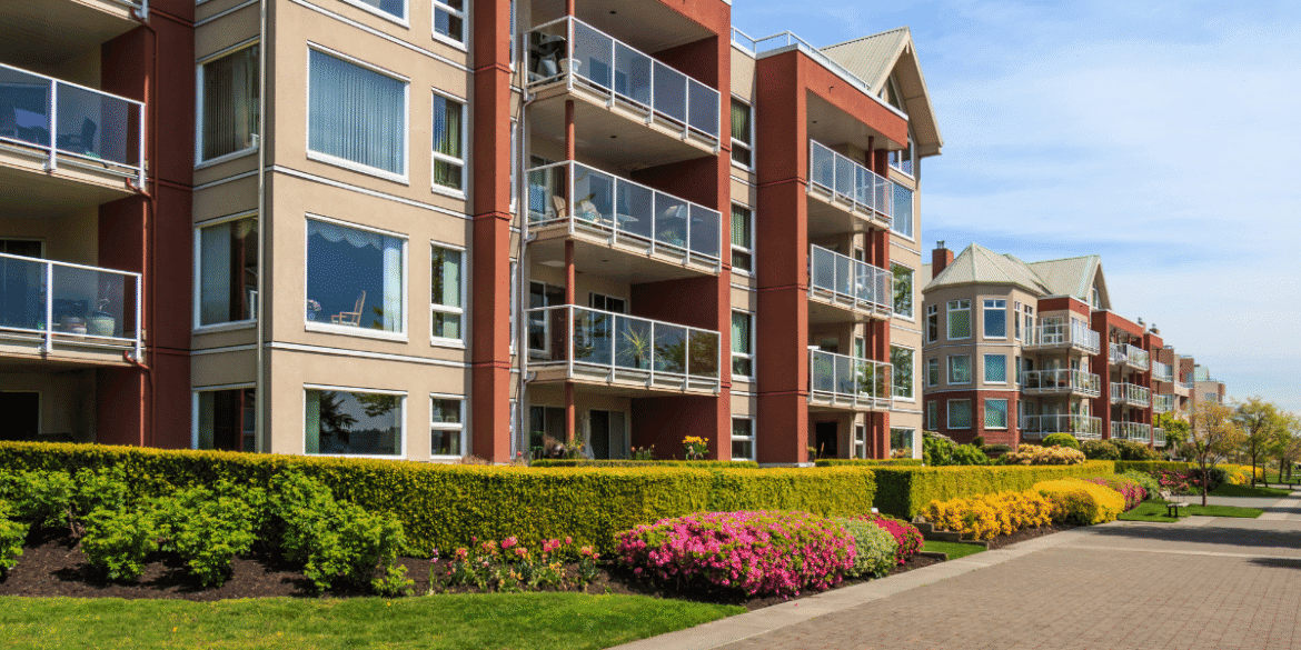 Modern apartment buildings with landscaped walkways and balconies in a multifamily residential community.